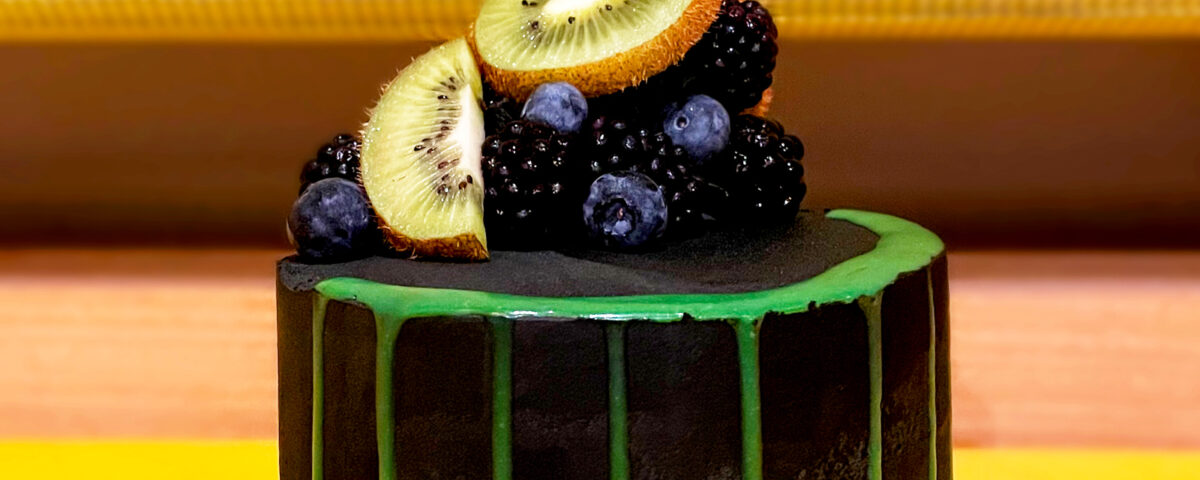 featured image of black buttercream chocolate cake with green drip